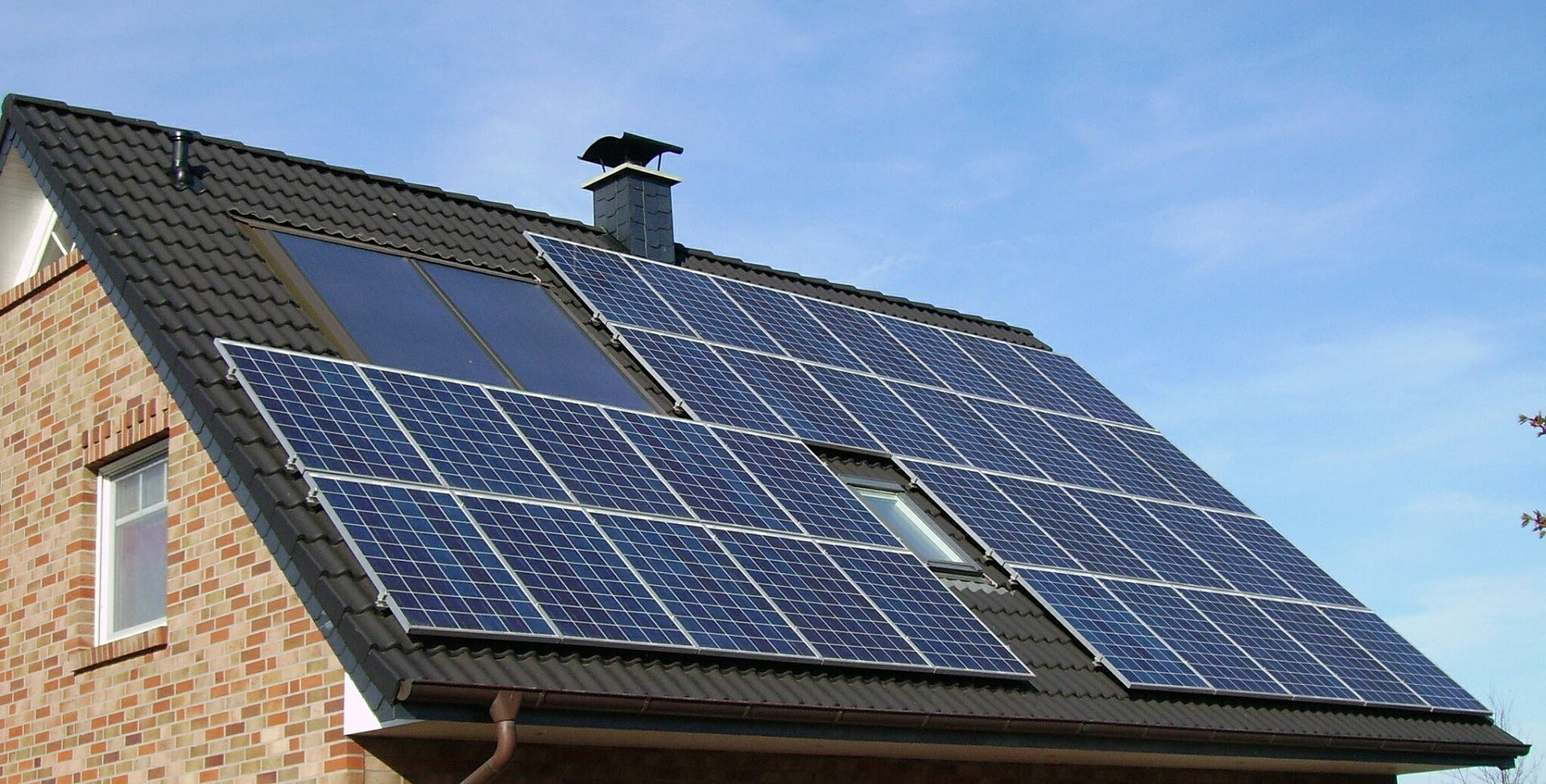 Solar panels being installed on a British home with a cost calculator overlay